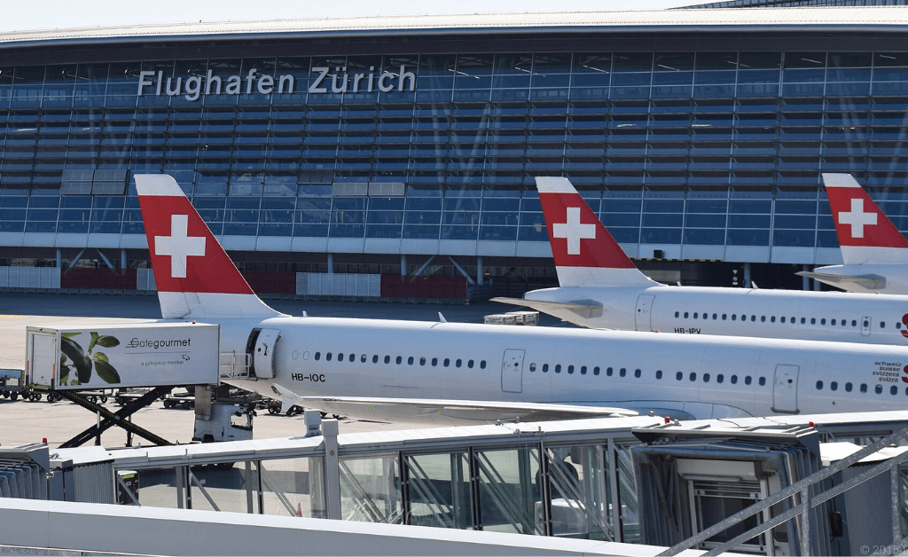 Zurich Airport terminal with Swiss Airlines planes parked at the gate.