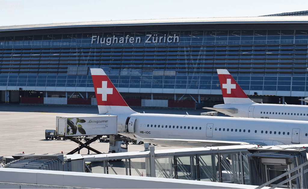 Zurich Airport Swiss Airlines Terminal with Aircrafts and Swiss Flags.