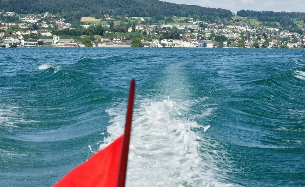 Scenic boat tour on Lake Zürich with a view of the Golden Coast, showcasing luxurious lakeside villas, lush greenery, and crystal-clear waters.