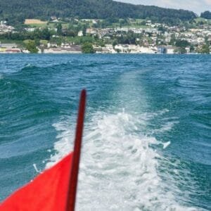 Scenic boat tour on Lake Zürich with a view of the Golden Coast, showcasing luxurious lakeside villas, lush greenery, and crystal-clear waters.