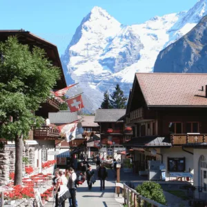 Charming street scene in Mürren village, Switzerland, with snow-capped mountains in the background.