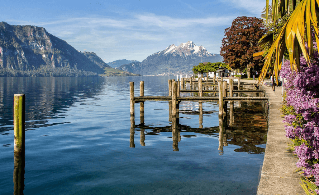 Scenic view of Weggis, Switzerland, on Lake Lucerne with a wooden pier and Mount Rigi in the background.