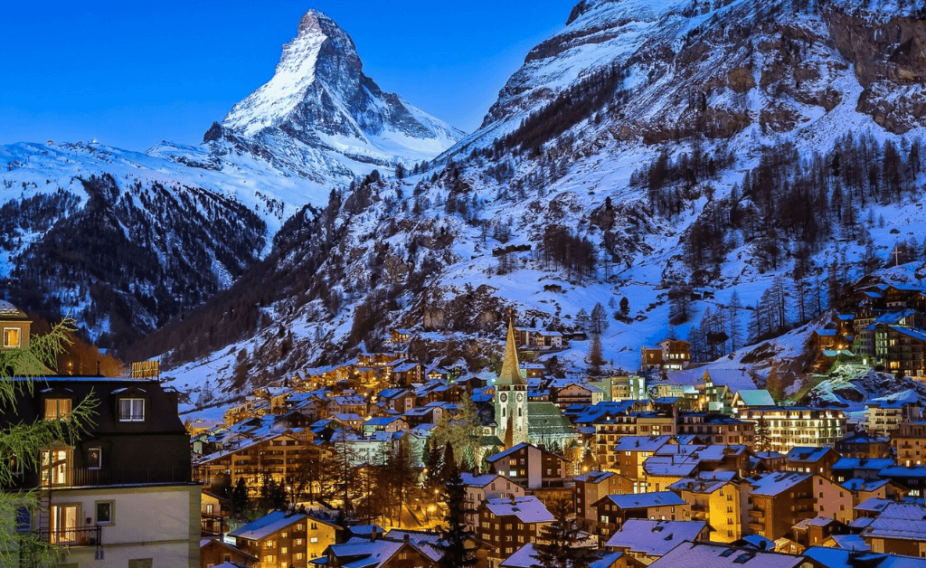 Night view of Zermatt village with the Matterhorn in the background.
